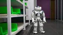 A humanoid robot next to a shelf with astonished face.