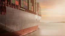 A photo taken from the right side of a big container ship.