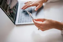 A woman paying online with her laptop and the credit card.