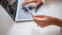 A woman paying online with her laptop and the credit card.