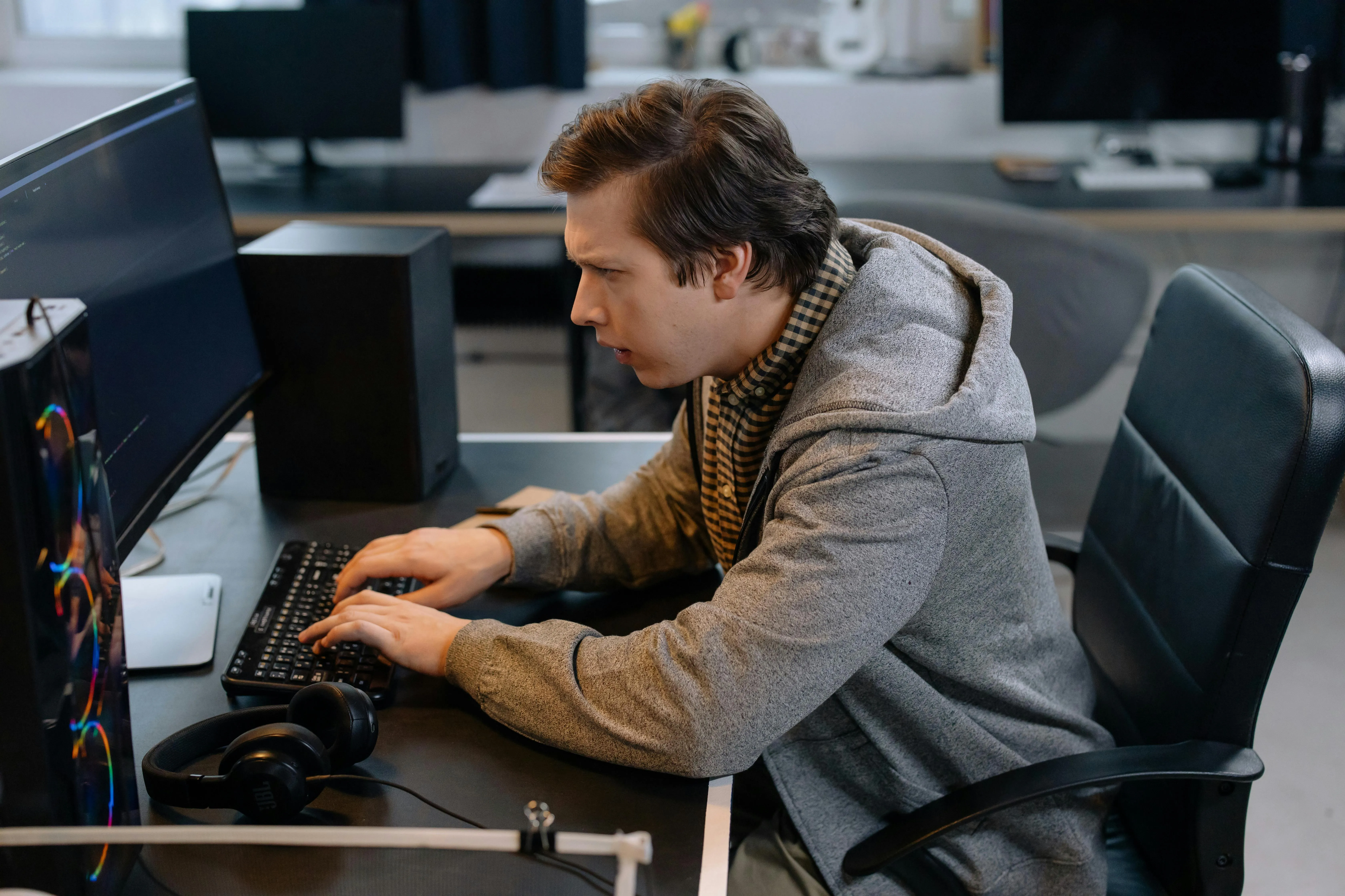 Software dev coding with confused face.