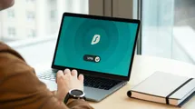 A person using a laptop and connecting to a vpn service.